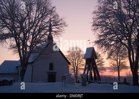 Alberi circostante Chiesa Bellfry torre campanaria della luce della sera neve Inverno in Svezia Foto Stock