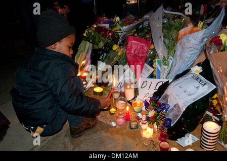 Come un omaggio a Nelson Mandela a bambini e adulti in lutto per la sua morte e portato fiori & messaggi e candele accese sotto il suo Foto Stock