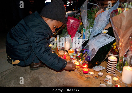 Come un omaggio a Nelson Mandela a bambini e adulti in lutto per la sua morte e portato fiori & messaggi e candele accese sotto il suo Foto Stock