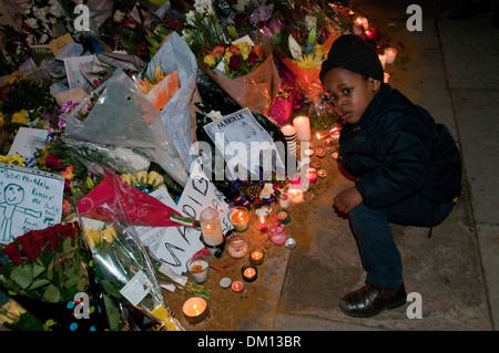 Come un omaggio a Nelson Mandela a bambini e adulti in lutto per la sua morte e portato fiori & messaggi e candele accese sotto il suo Foto Stock