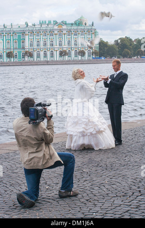 Russia, San Pietroburgo, sposi in posa per la telecamera sulla Strelka sull isola Vasilievsky Foto Stock