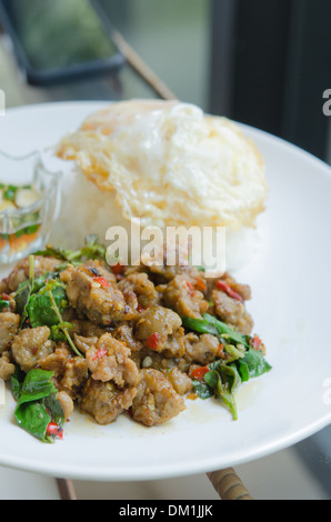 Saltate in padella la carne di maiale tritata con il peperoncino , dolce basilico servito con riso al vapore e uovo fritto Foto Stock