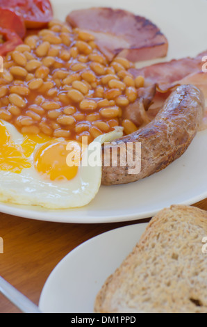 Prima colazione inglese tradizionale - uovo, fagioli , toast, salsicce e pancetta,