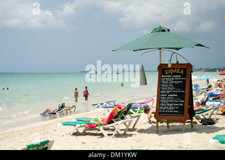La scena sulla spiaggia e Menu Kuyaba segno su 7 miglia di spiaggia a Negril, Giamaica Foto Stock