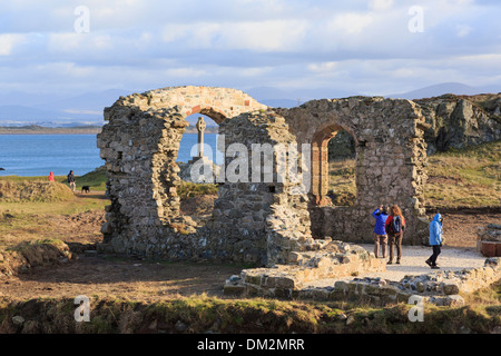 Visitatori esplorare la storica del XVI secolo le rovine di San Dwynwen la chiesa su Ynys Llanddwyn Island Isola di Anglesey North Wales UK Foto Stock