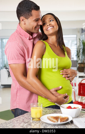 La donna incinta e il marito avente la colazione nella cucina Foto Stock