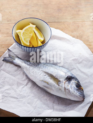 Materie dorate orate di testa su carta bianca con limone Foto Stock