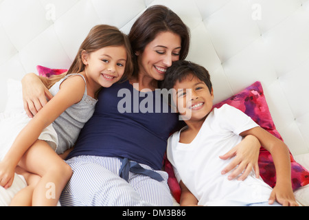 Madre e bambini relax nel letto pigiami da indossare Foto Stock