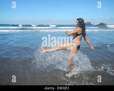 Donna, ragazza, adolescente, mare, Tenerife, Isole canarie, Spagna, Europeo, divertente, gioia, acqua, bikini, splash, Foto Stock