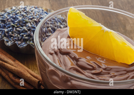 Mousse al cioccolato guarnita con frutta di arancia in un bicchiere di vetro Foto Stock