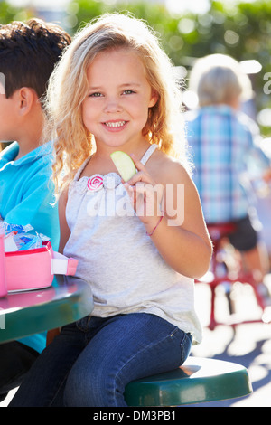Pupilla elementari seduta a tavola a mangiare il pranzo Foto Stock