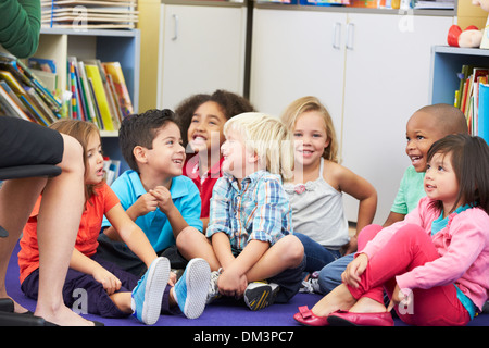 Gruppo di alunni elementari in Aula ascoltando insegnante Foto Stock