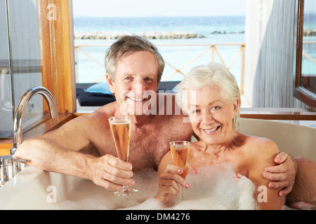 Coppia senior relax nella vasca da bagno di bere champagne insieme Foto Stock