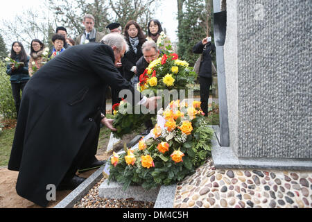 Berlino, Germania. Undicesimo Dec, 2013. John Rabe's nipote Tommaso Rabe (anteriore) stabilisce una corona durante la cerimonia di inaugurazione del monumento di John Rabe a Berlino, Germania, a Dic. 11, 2013. Cerimonia di apertura del cimitero commemorativo dedicato a Siemens imprenditore John Rabe, che ha salvato la vita di centinaia di migliaia di cinesi in Nanjing durante la II Guerra Mondiale, si è tenuta a Berlino mercoledì. (Xinhua/Zhang Fan) Credito: Zhang ventola/Xinhua/Alamy Live News Foto Stock