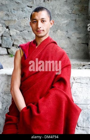 Ladakh, India - 18 Luglio 2009: un monaco buddista in un abito rosso appare nella fotocamera e pone per un ritratto nel monastero di Rizong Foto Stock