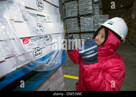 Noi del dipartimento dell'agricoltura alimentare ispettore di sicurezza esamina una spedizione di carne congelata importata nel porto di New Orleans Novembre 21, 2013 a New Orleans, LA. Foto Stock