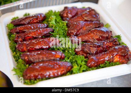 BBQ ali di pollo su un letto di prezzemolo Foto Stock