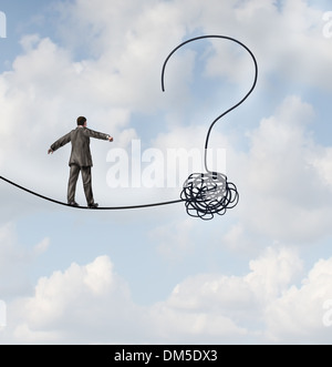 Incertezza del rischio e la pianificazione di un nuovo cammino come un imprenditore a camminare su una corda che getets aggrovigliati e sagomato come un punto interrogativo come una metafora per la confusione presso la strada davanti come un concetto di business di trovare soluzioni per cambiare per il successo. Foto Stock