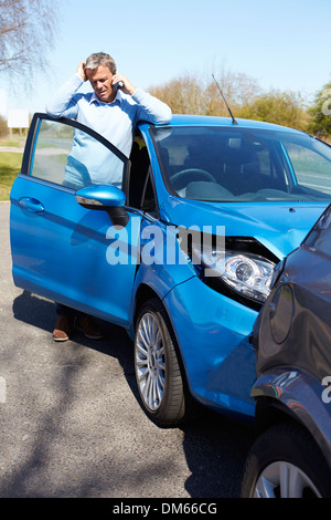 Sottolineato Conducente seduto alla strada dopo incidente stradale Foto Stock