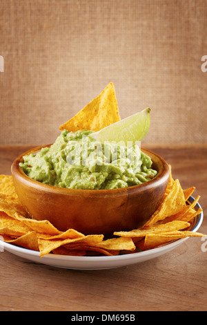 Mexican nachos fatti a mano con salsa guacamole su un tavolo di legno Foto Stock