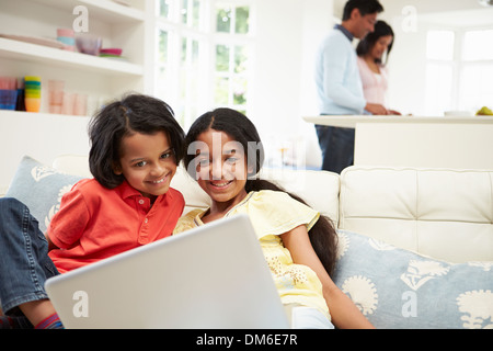 Famiglia indiana con il portatile a casa Foto Stock