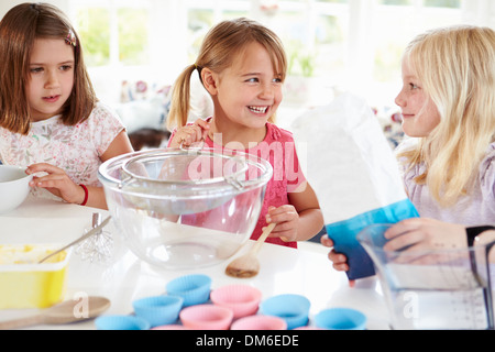 Le tre ragazze rendendo i tortini in cucina Foto Stock