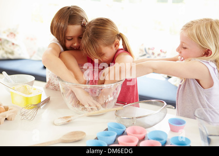 Le tre ragazze rendendo i tortini in cucina Foto Stock