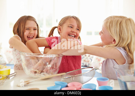 Le tre ragazze rendendo i tortini in cucina Foto Stock