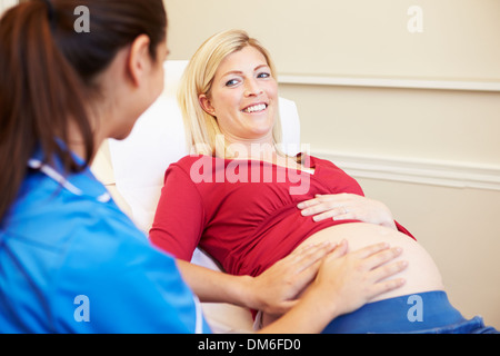 Donna incinta essendo dato Ante Natal controllare da un infermiere Foto Stock
