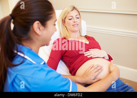 Donna incinta essendo dato Ante Natal controllare da un infermiere Foto Stock