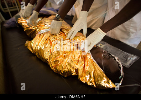 HIV AIDS paziente avvolto in lamina di alluminio per mantenere il caldo in ospedale in auto Foto Stock