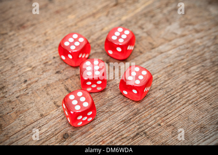 Sei numeri su facce di cinque dadi rossi sul pavimento in legno Foto Stock