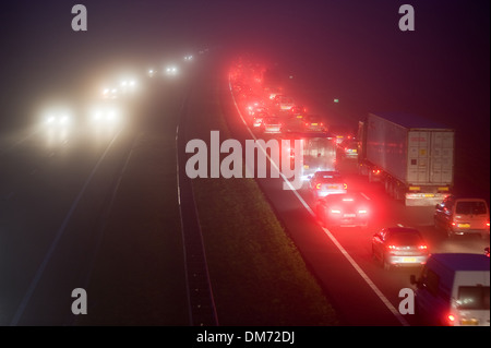 La nebbia durante le ore di punta op una sera di dicembre su una autostrada nei Paesi Bassi Foto Stock