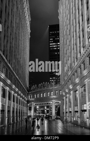 Business gli uomini e le donne a casa a piedi su un freddo inverno umido la sera vicino al Wrigley Building a Chicago, Illinois, Stati Uniti d'America Foto Stock