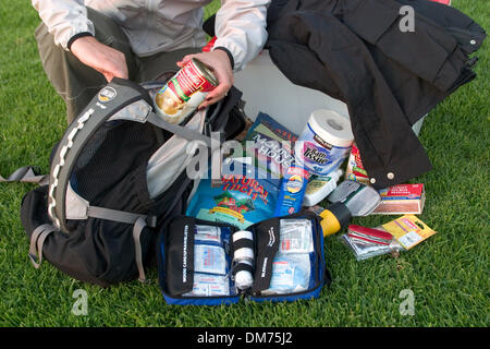 Set 29, 2005; Laguna Niguel, CA, Stati Uniti d'America; una donna si prepara un disastro survival pack con kit di primo soccorso e kit di sopravvivenza, inclusi alimenti acqua, la luce del flash, carta igienica, fiammiferi, coltello, spazio di emergenza coperte. Kit simile vengono utilizzati quando i terremoti, uragani, cicloni, attacchi terroristici o talvolta solo quando i blackout accadere. Questo kit è simile a un kit di emergenza per la tua casa Foto Stock