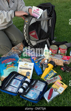 Set 29, 2005; Laguna Niguel, CA, Stati Uniti d'America; una donna si prepara un disastro survival pack con kit di primo soccorso e kit di sopravvivenza, inclusi alimenti acqua, la luce del flash, carta igienica, fiammiferi, coltello, spazio di emergenza coperte. Kit simile vengono utilizzati quando i terremoti, uragani, cicloni, attacchi terroristici o talvolta solo quando i blackout accadere. Questo kit è simile a un kit di emergenza per la tua casa Foto Stock