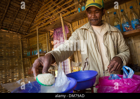 L'uomo la vendita di zucchero nel suo negozio a Fenerive Est distretto, Madagascar. Foto Stock