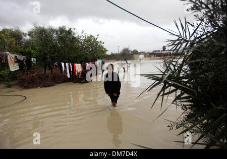 Rafah nella striscia di Gaza, Territori palestinesi. 12 Dic, 2013. Un ragazzo palestinese passeggiate in un invaso street in seguito a piogge intense in un giorno di tempesta a Rafah nel sud della striscia di Gaza, Dicembre 12, 2013. Le strade di Gaza sono inondati dopo solo tre ore di heavy rain che provoca gravi danni infrastrutturali e inondate molte case Credit: Ashraf Amra/immagini APA/ZUMAPRESS.com/Alamy Live News Foto Stock