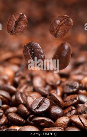 4 La caduta di fagioli e buio chicchi di caffè tostati lo sfondo con il primo piano di messa a fuoco Foto Stock