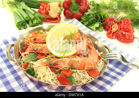 Gamberi con mie tagliatelle, limone, peperone, aneto e coriandolo su uno sfondo luminoso Foto Stock