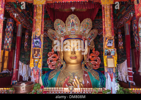 La metà superiore di una statua d'oro di Buddha è visto dal colorato pavimento superiore di un tempio nel monastero di Thiksey in Ladakh. Foto Stock