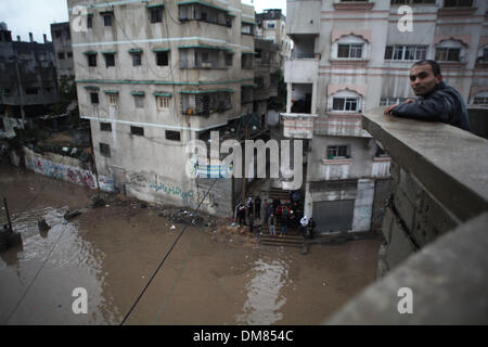 La striscia di Gaza, Territori palestinesi. 12 Dic, 2013. Un palestinese uomo orologi in un invaso street dopo forti piogge in un giorno di tempesta nel nord della Striscia di Gaza, Dicembre 12, 2013. Le strade di Gaza sono inondati dopo solo tre ore di heavy rain che provoca gravi danni infrastrutturali e inondate diverse abitazioni.Foto: Ahmed Deeb/NurPhoto Credito: Ahmed Deeb/NurPhoto/ZUMAPRESS.com/Alamy Live News Foto Stock