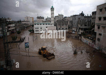 La striscia di Gaza, Territori palestinesi. 12 Dic, 2013. Civile palestinese utilizzo per la difesa di un bulldozer che lavorano in una strada allagata dopo forti piogge in un giorno di tempesta nel nord della Striscia di Gaza, Dicembre 12, 2013. Le strade di Gaza sono inondati dopo solo tre ore di heavy rain che provoca gravi danni infrastrutturali e inondate diverse abitazioni.Foto: Ahmed Deeb/NurPhoto Credito: Ahmed Deeb/NurPhoto/ZUMAPRESS.com/Alamy Live News Foto Stock