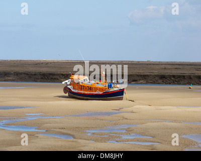 Scialuppa di salvataggio spiaggiata a bassa marea a Wells-next-Mare, Norfolk, Inghilterra Wells-next-il-mare. Norfolk, Inghilterra Foto Stock