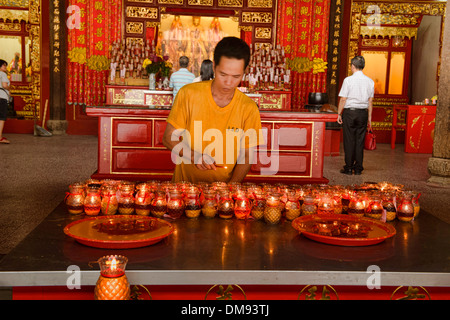 Accendendo candele per fortuna in Kong Hock Keong santuario di Georgetown di Penang, Malaysia Foto Stock