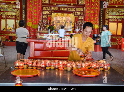 Accendendo candele per fortuna in Kong Hock Keong santuario di Georgetown di Penang, Malaysia Foto Stock