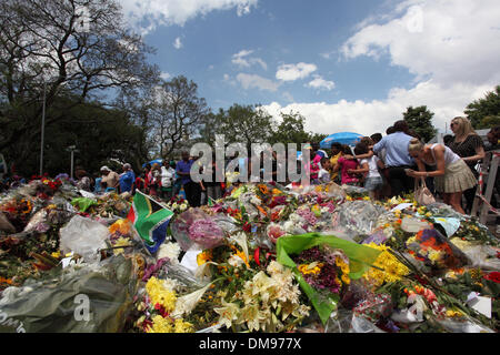 Johannesburg, Sud Africa. 12 Dic, 2013. Persone in lutto si riuniscono per stabilire i fiori e pagare i loro rispetti al di fuori di Nelson Mandela in casa di Houghton Johannesburg. Sud Africa giovedì 12 dicembre 2013 foto da Zute Lightfoot/Alamy Live News Foto Stock