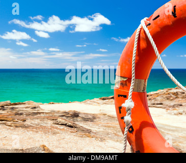 Arancio brillante surf live risparmio anello flottante con il blu oceano dietro Foto Stock