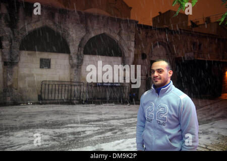 Gerusalemme, Gerusalemme, Territorio palestinese. 12 Dic, 2013. Un uomo palestinese in posa per una fotografia di una strada coperta di neve durante una tempesta di neve in Gerusalemme la città vecchia sul dicembre 12, 2013. Gerusalemme è coperto di neve Giovedi, il più pesante della tempesta di neve che colpisce la città dal 1953 come meteorologi doppiato Credito: Saeed Qaq APA/images/ZUMAPRESS.com/Alamy Live News Foto Stock