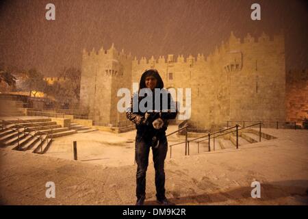 Gerusalemme, Gerusalemme, Territorio palestinese. 12 Dic, 2013. Un uomo palestinese in posa per una fotografia nella parte anteriore della porta di Damasco durante una tempesta di neve in Gerusalemme la città vecchia sul dicembre 12, 2013. Gerusalemme è coperto di neve Giovedi, il più pesante della tempesta di neve che colpisce la città dal 1953 come meteorologi doppiato Credito: Saeed Qaq APA/images/ZUMAPRESS.com/Alamy Live News Foto Stock